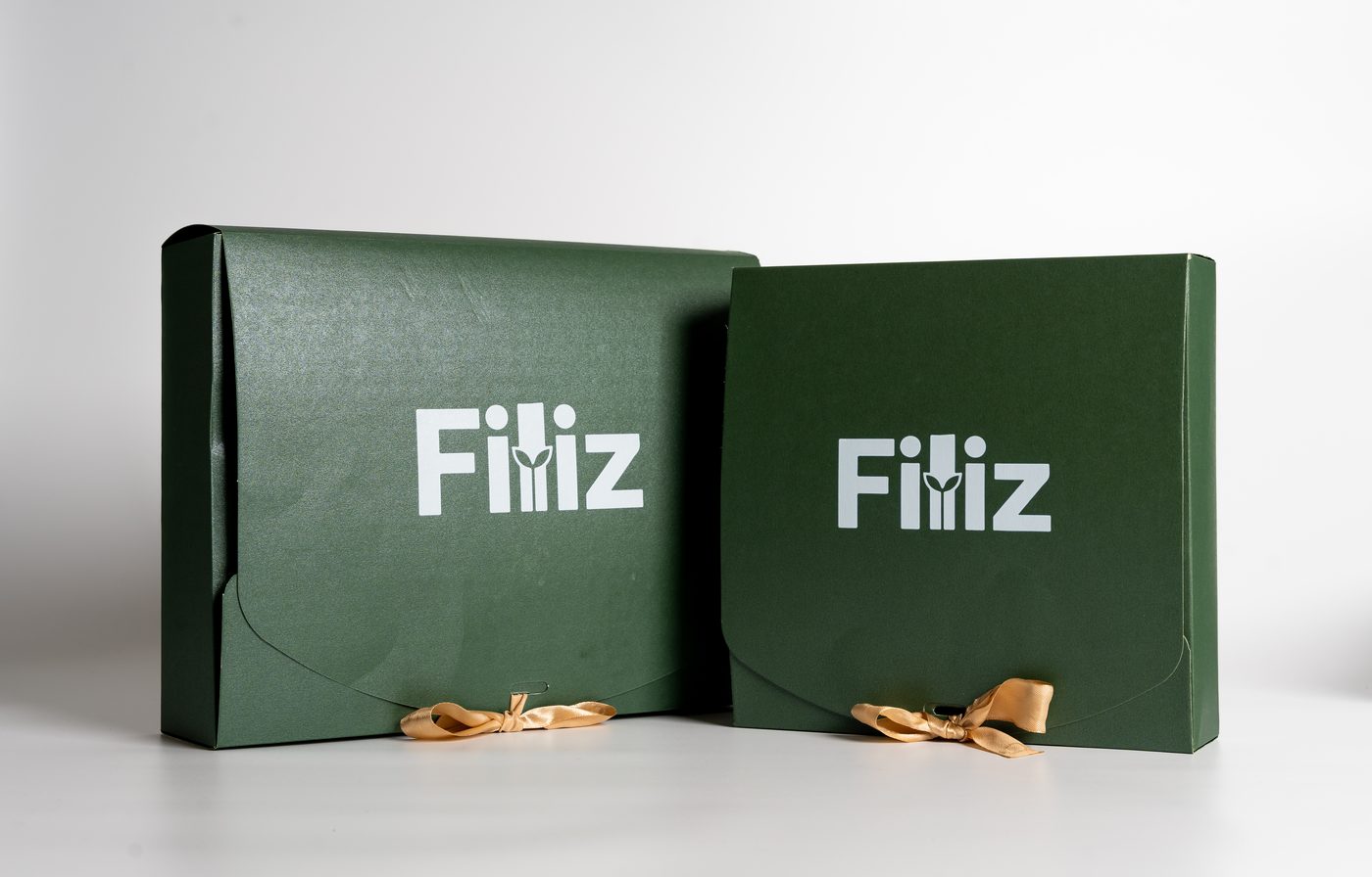 Two Filiz boxes tied with gold ribbon — returnable packaging